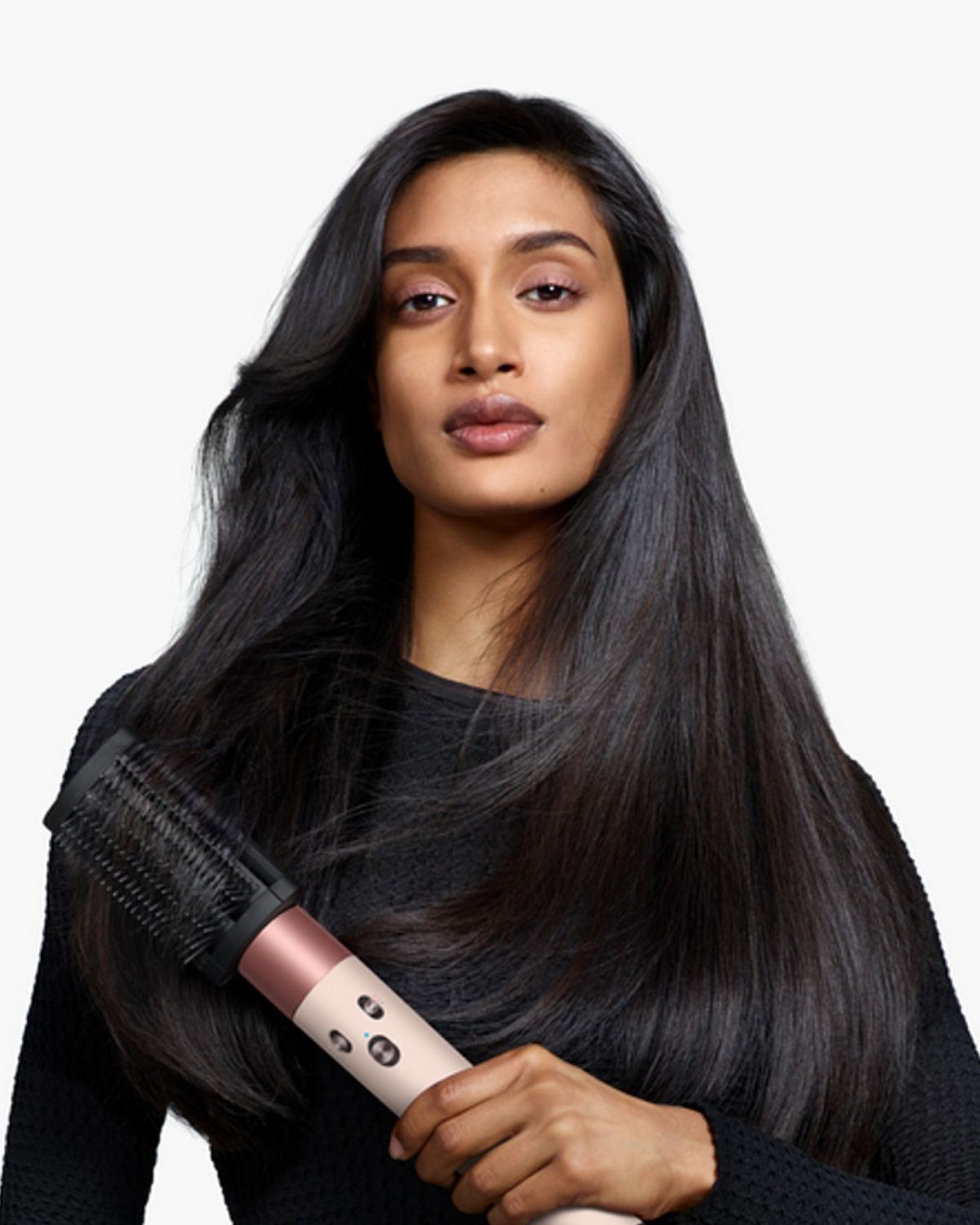 Model holding the Dyson Airwrap ID multi-styler and dryer with the Anti-tangle loop brush.